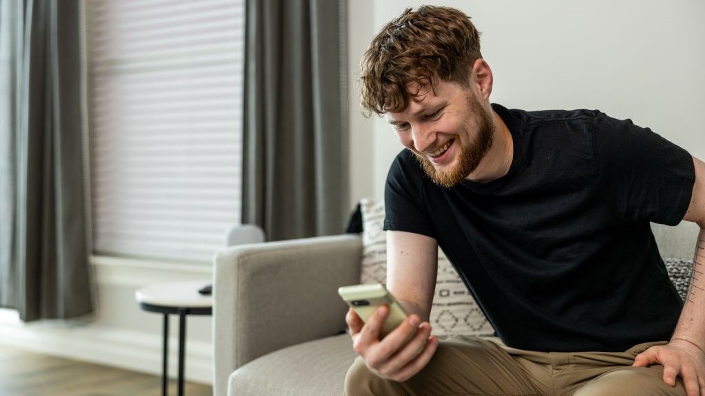 Man sitting on couch holding cellphone